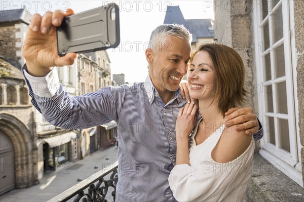 Caucasian couple posing for cell phone selfie