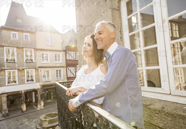 Caucasian couple smiling on balcony in city