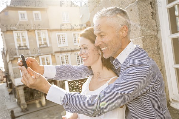 Caucasian couple posing for cell phone selfie