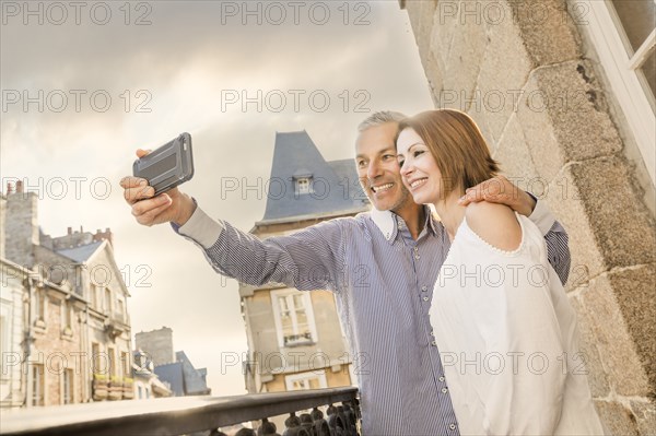 Caucasian couple posing for cell phone selfie