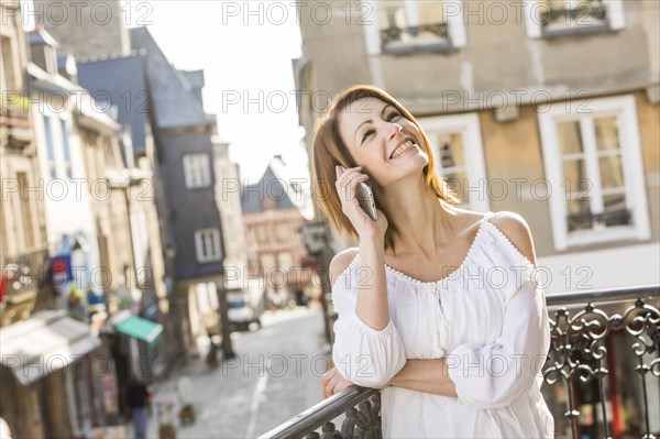 Caucasian woman talking on telephone in city