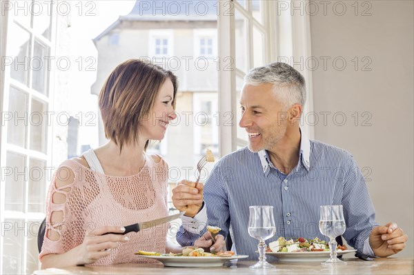 Caucasian couple eating salad in restaurant