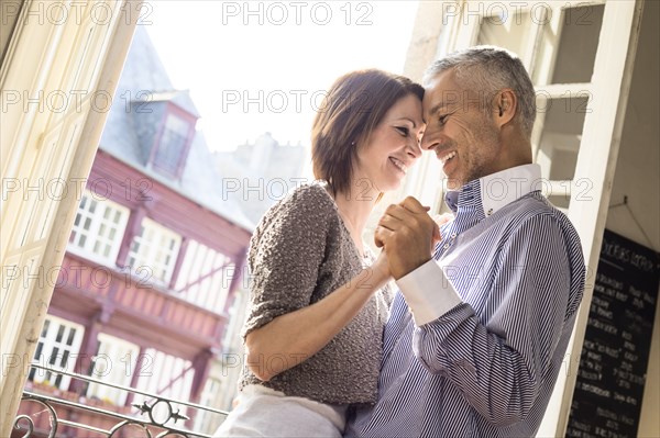 Caucasian couple dancing near doorway