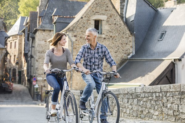 Caucasian couple riding bicycles in city