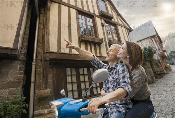 Caucasian couple sightseeing on motor scooter