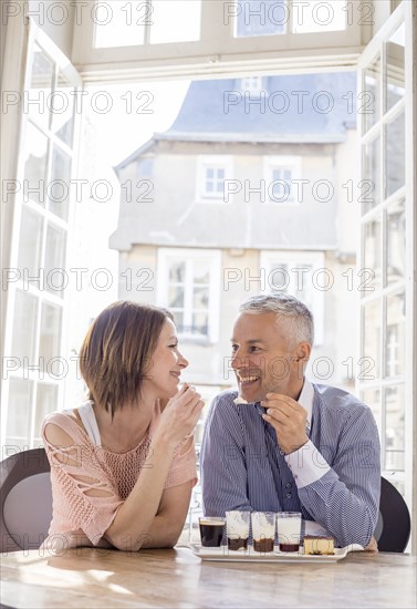Caucasian couple eating dessert near doorway