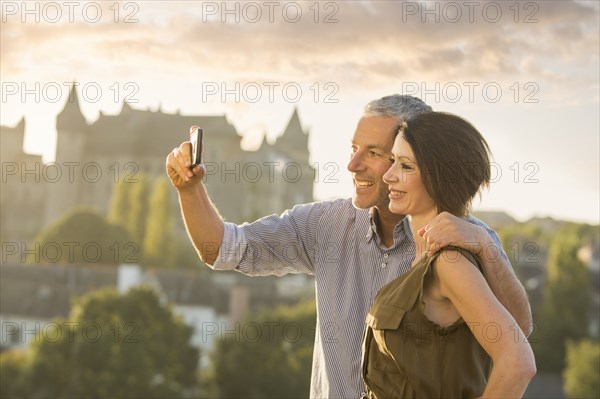 Caucasian couple posing for cell phone selfie