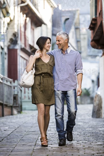 Caucasian couple hugging while walking in city