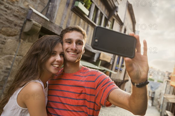 Caucasian couple posing for cell phone selfie