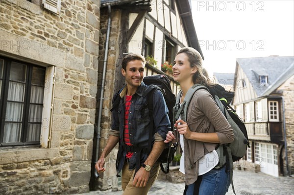 Caucasian couple backpacking in city