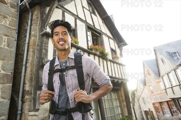 Asian man backpacking in city