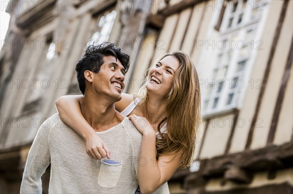 Man carrying woman piggyback in city