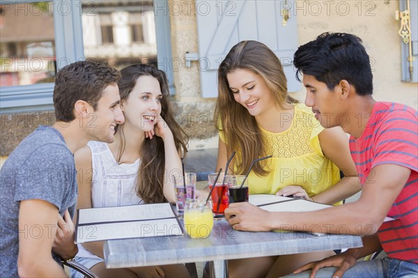 Friends reading menus at restaurant