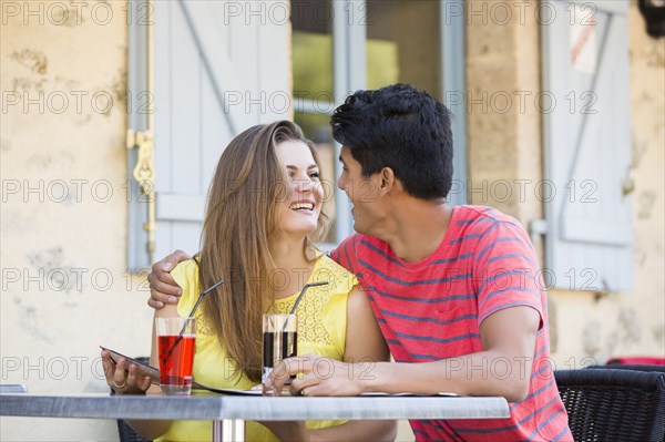 Couple reading menu and hugging at restaurant