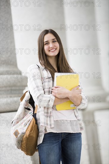 Caucasian woman carrying school notebook