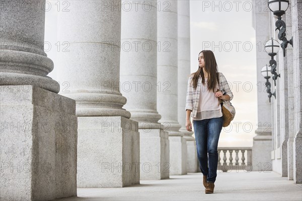 Caucasian woman carrying backpack at school