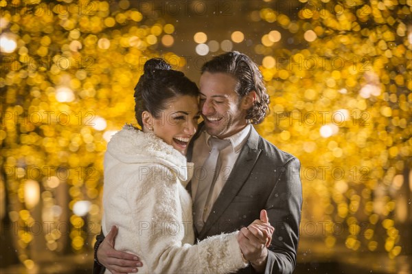 Caucasian couple dancing outdoors at night