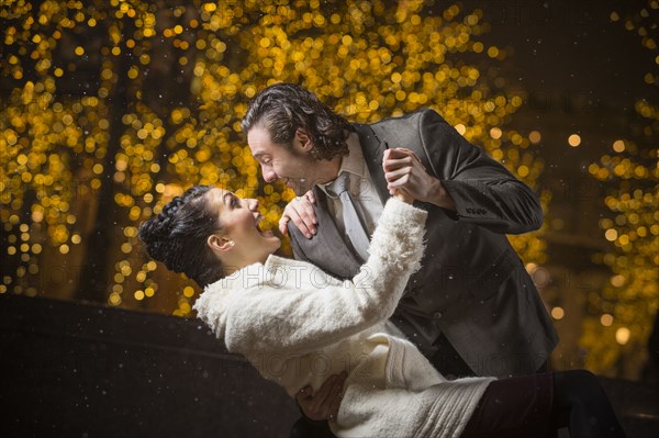 Caucasian couple dancing outdoors at night