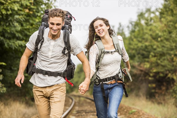 Caucasian couple walking on train tracks
