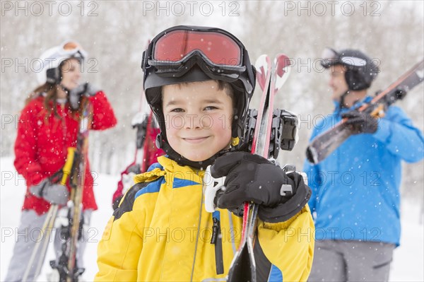 Portrait of smiling Caucasian boy carrying skis