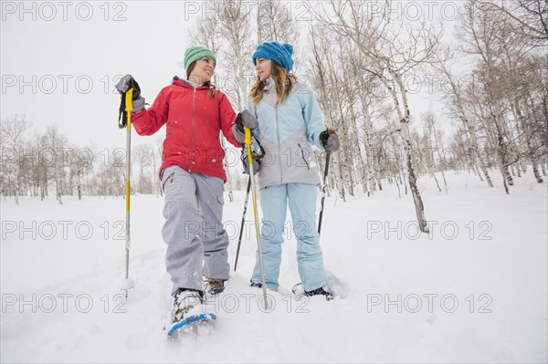 Caucasian mother and daughter snowshoeing