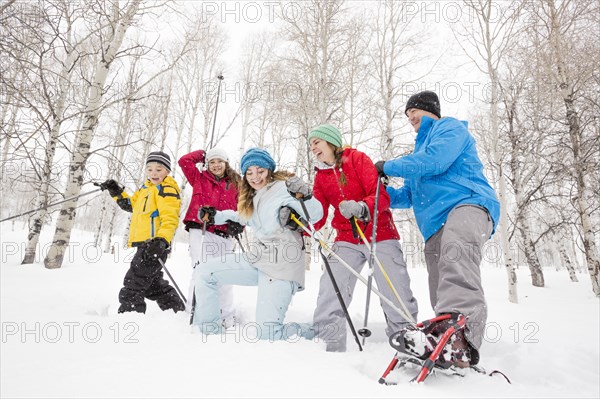 Smiling Caucasian family snowshoeing