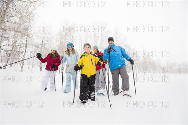 Portrait of smiling Caucasian family snowshoeing