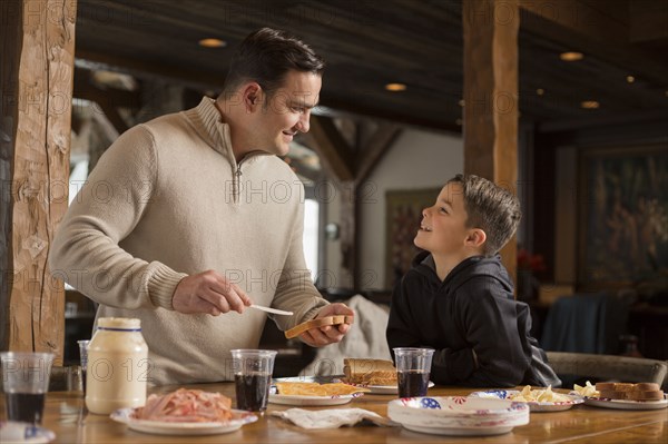 Caucasian father making sandwich for son at table