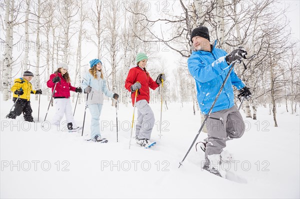 Caucasian family snowshoeing in winter