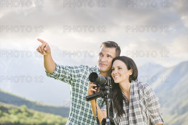 Man pointing for woman photographing with camera