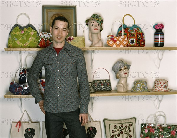 Mixed race man standing in retro purse shop