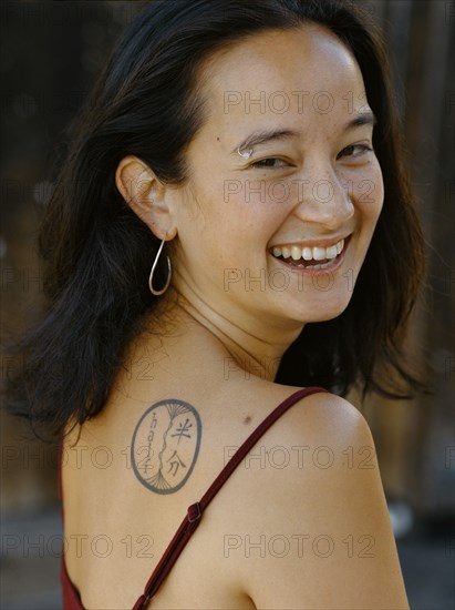 Smiling mixed race woman with tattoo