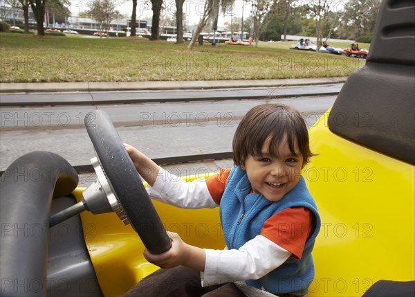 Mixed race boy driving go-cart