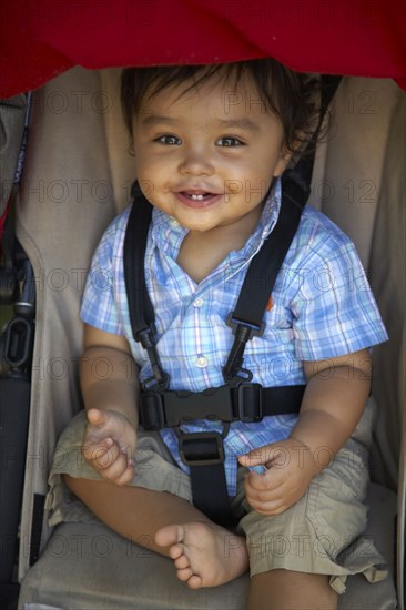 Mixed race boy sitting in stroller