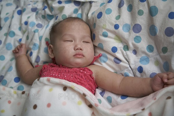 Baby girl sleeping in bed