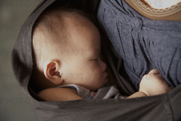 Mother carrying baby in sling