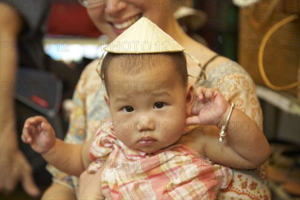 Baby girl wearing Asian hat