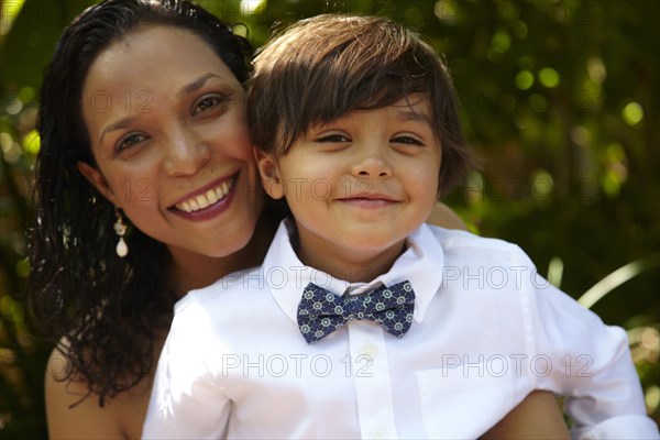 Smiling mother holding son on her lap