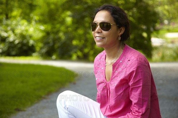 Smiling mixed race woman sitting outdoors