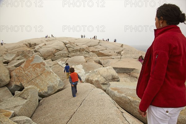 Mother and sons walking on rocks