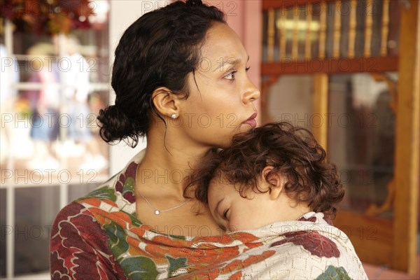 Mother holding sleeping son