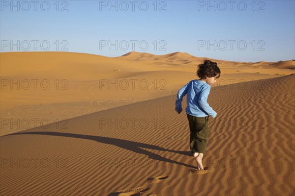 Mixed race boy running in desert