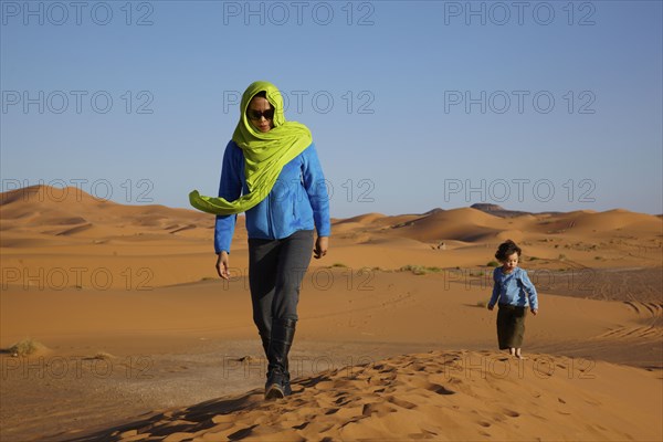 Mother and son walking in desert