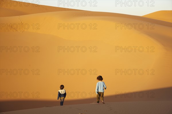 Mixed race brothers walking in desert