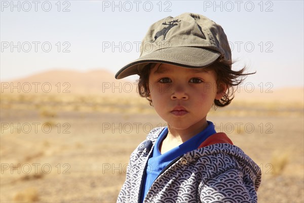 Serious mixed race boy in cap