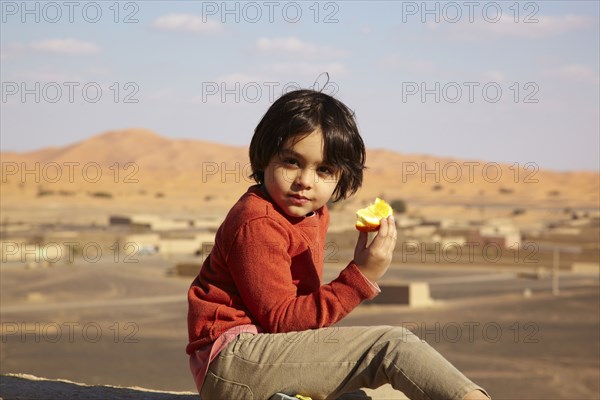 Mixed race boy eating fruit