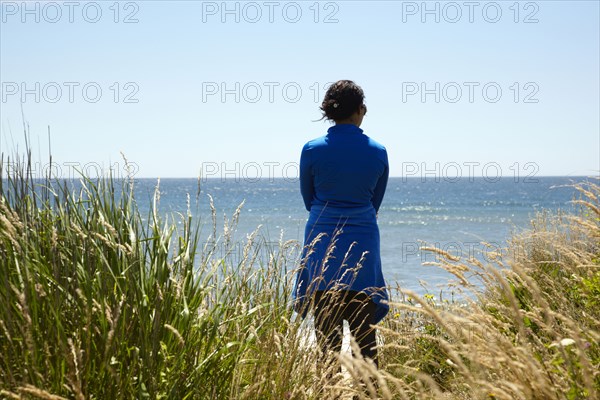 Mixed race woman looking at ocean