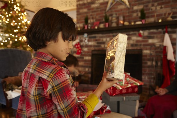 Mixed race boy opening Christmas present