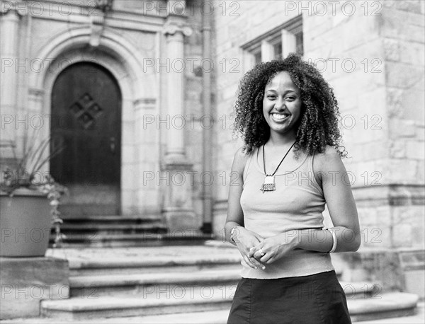 Mixed race woman smiling by church