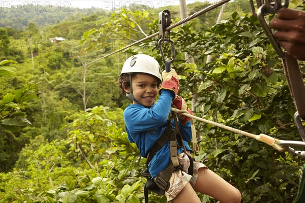 Mixed race boy zip lining